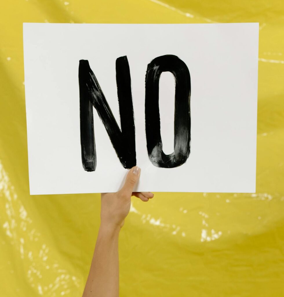 una persona sosteniendo un papel que dice "NO"